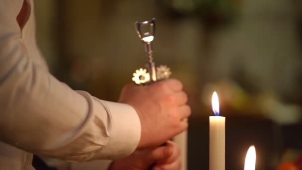 Lumière faible. profondeur de champ étroite. les mains des hommes ouvrent une bouteille de vin tire-bouchon — Video