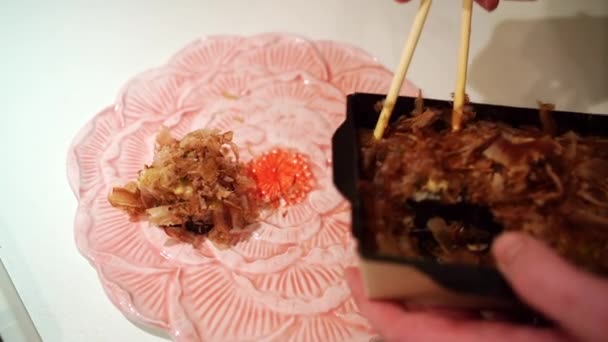 Bestellen von Imbissen. auf einem Teller japanische Rollen mit knusprigen Thunfischspänen — Stockvideo