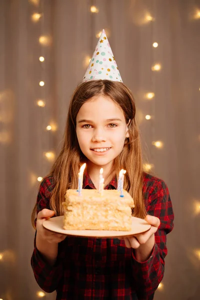 Menina adolescente feliz com bolo de aniversário. tradição de fazer desejo e apagar o fogo — Fotografia de Stock