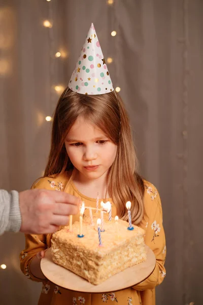 Menina com bolo de aniversário. tradição de fazer desejo e apagar o fogo — Fotografia de Stock