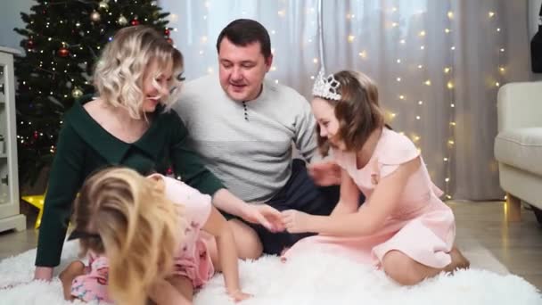 Feliz familia en el suelo de la casa antes de árbol de Navidad tontos alrededor y se ríe. — Vídeos de Stock