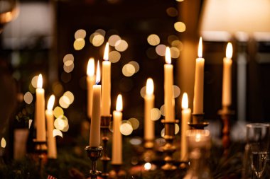 Karanlık bir iç mekanda şamdanlarda mum yakmak. Romantik yemek. Yeni Yıl