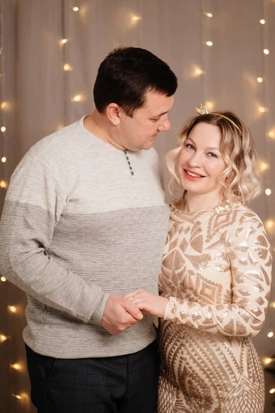 Coppia sposata. un uomo e una donna si coccolano sullo sfondo di una ghirlanda. — Foto Stock