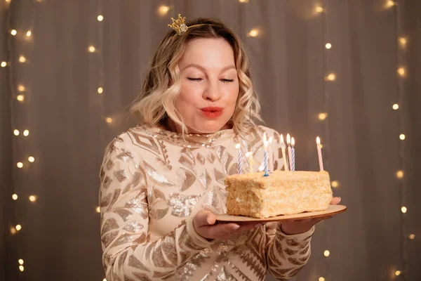 Mulher loira bonita em pequena coroa na cabeça com um bolo de aniversário e velas. — Fotografia de Stock