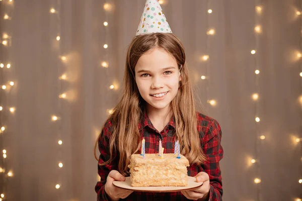 Gelukkig tienermeisje met verjaardagstaart. traditie om wensen te maken en vuur uit te blazen — Stockfoto