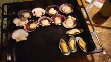 Az ışık. Midyeler ve istiridyeler fırında pişirmek için bir kabın üzerine serilirler.