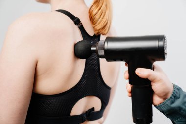 Kadın masaj silahı kullanıyor. tıbbi spor aygıtı. 
