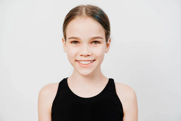 Teen girl with collected hair in a black T-shirt stands on a white background — Stock Photo, Image