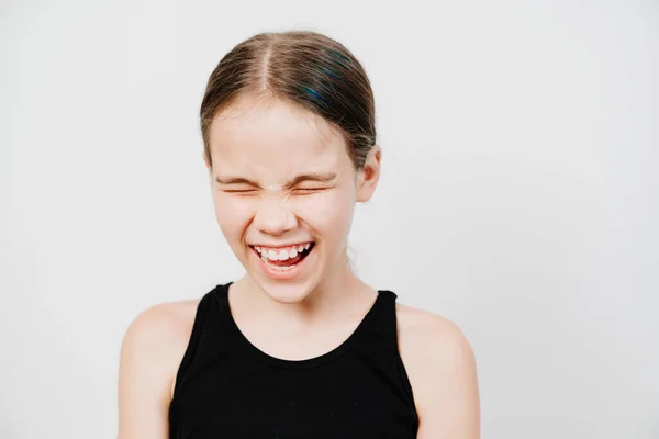 Teen girl with collected hair in a black T-shirt stands on a white background — Stock Photo, Image