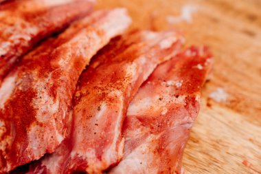 Domuz pirzolası üzerine tuz, karabiber ve kırmızı biber serpiştirilmiş.