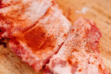 Domuz pirzolası üzerine tuz, karabiber ve kırmızı biber serpiştirilmiş.