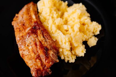 Siyah arka planda pişmiş domuz pirzolası.