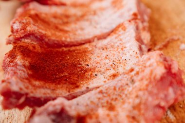 Domuz pirzolası üzerine tuz, karabiber ve kırmızı biber serpiştirilmiş.