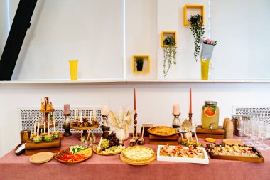 Yemek servisi. Tatil için aperatifler, turtalar ve içeceklerle dolu bir masa. Açık büfe.