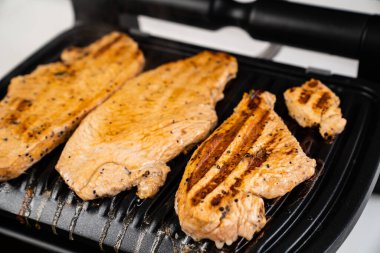 Et elektrikli ızgarada pişirilir.