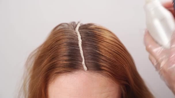 Αυτο-χρωματισμός των γκρίζων ριζών των μαλλιών στο κεφάλι μιας γυναίκας. — Αρχείο Βίντεο