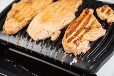 Et elektrikli ızgarada pişirilir.