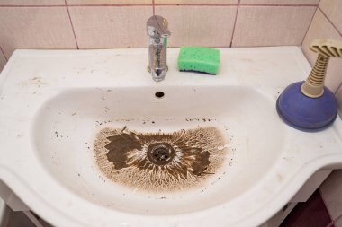 Tıkanma ortadan kalktıktan sonra kirli lavaboya su çekiliyor.