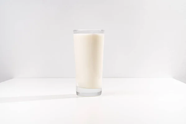 Un vaso de leche sobre un fondo blanco. Lugar para la inscripción. — Foto de Stock