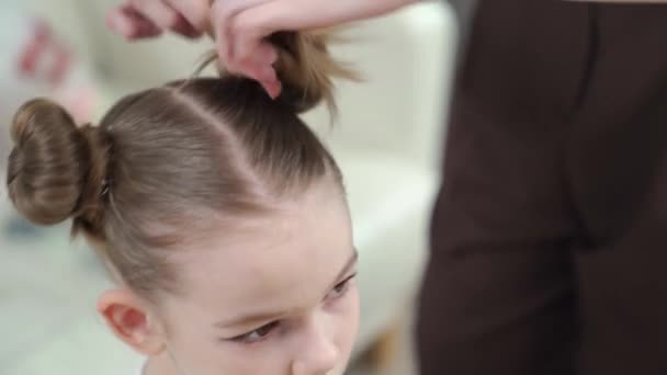 Mamma gör en frisyr till sin dotter. ögonmakeup. — Stockvideo