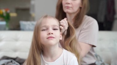 Anne kızını tarıyor ve iki kuyruk yapıyor, acele et, hemen değil..