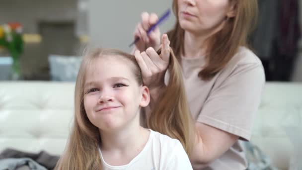 Mamá peina a su hija y hace dos colas, date prisa, resulta que no inmediatamente. — Vídeos de Stock