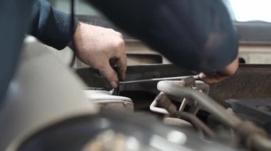 Tamirci şok emici eklentisini söktü. Otomobil servisi, araba tamiri.