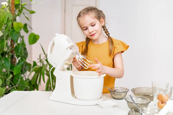어린 소녀는 물에 넣을 수있는 믹서에 반죽이나 크림을 만든다. — 스톡 사진