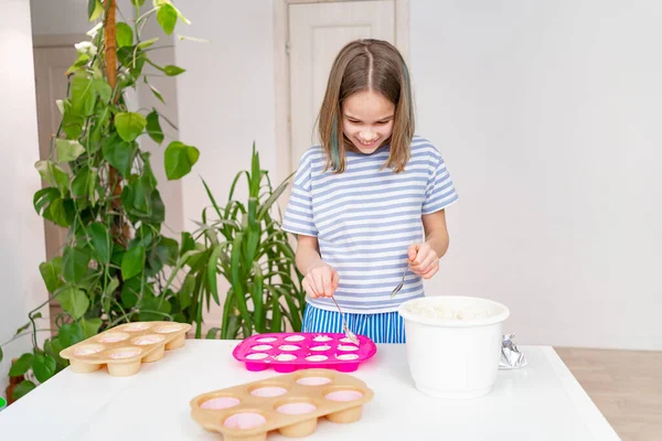 10 대 소녀가 컵 케익용 실리콘으로 반죽을 만든다. — 스톡 사진