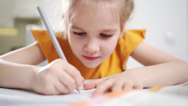 Een geconcentreerd schoolmeisje doet haar huiswerk. — Stockvideo
