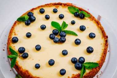 Yaban mersini ve nane yapraklarıyla süslenmiş ev yapımı cheesecake.. 
