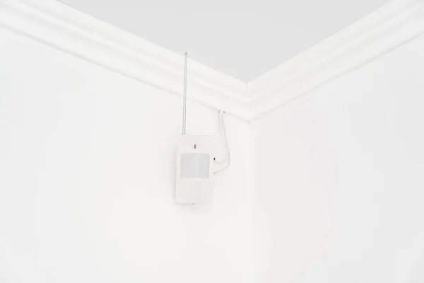 The motion sensor on the white wall. device that tracks the movement of objects.