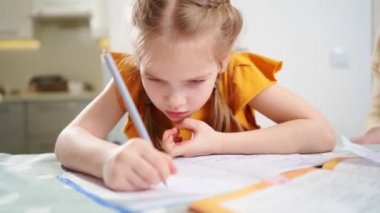 Düşünceli küçük bir liseli kız ödevini yapıyor. Gergin ve tırnak yiyor.