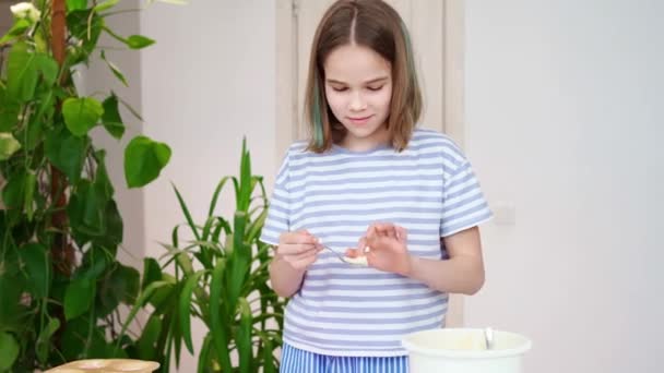 Tonårstjej lägger degen i silikon form för cupcakes och smaker hemma. — Stockvideo