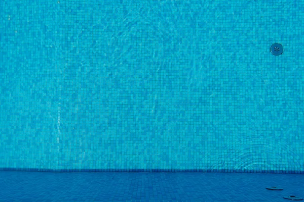 Вода в бассейне, дно с голубой черепицей. Купание и пляжный отдых. — стоковое фото