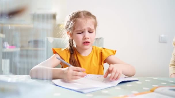 Una colegiala hace los deberes y llora. mamá se sienta a su lado explica — Vídeos de Stock