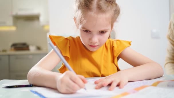 Een geconcentreerd en ijverig schoolmeisje doet haar huiswerk. — Stockvideo