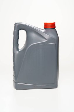 Beyaz arka planda makine yağı olan kırmızı kapaklı gri bir kutu. Motor parçaları arasındaki sürtünmeyi azaltmak için motor yağları. Araba servisi ve mağaza