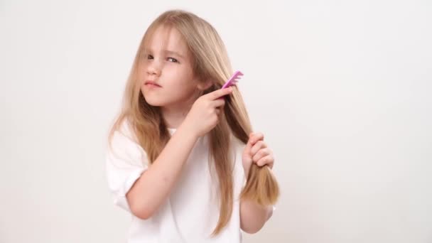 Drôle Petite Fille Peigne Les Cheveux Longs Enchevêtrés Sur Fond — Video