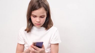 teenage girl types text in a phone on a white background. children's dependence on gadgets and social networks.