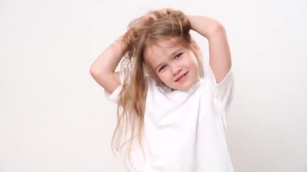Little girl ruffles long blond hair on her head. childs hair care. — Vídeo de Stock