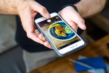 Akıllı telefonunda lezzetli ve güzel yiyecekler çekiyorsun. Sosyal ağlar, reklamlar ve kafe veya restoran menüleri için fotoğraflar.