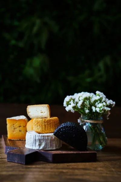 Assorted Cheese Heads Cutting Board Wooden Table Small Bouquet Flowers — Stock Photo, Image