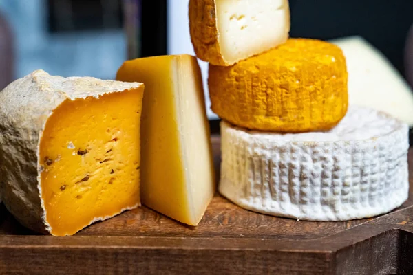 Tahta Bir Masanın Üzerindeki Kesme Tahtasındaki Çeşitli Peynir Kafalar Peynir — Stok fotoğraf