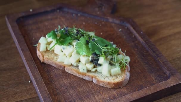 Bruschetta Com Queijo Verdes Põem Uma Tábua Corte Madeira Fotos — Vídeo de Stock