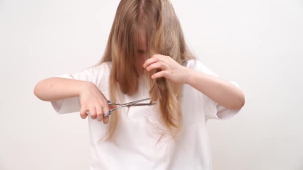 Küçük Kız Uzun Saçlarını Beyaz Arka Planda Makasla Kesiyor Bebek — Stok video