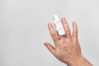 Beyaz arka planda parmağı düzeltmenin ortozu. Langet, yaralanmalara bağlı olarak parmaklardaki parmak kemiklerini iyileştiriyor. Ortopedik aksesuarlar. eczane ve tıbbi ekipman.