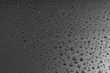 Siyah arka planda bir damla su. Doku. Yüzeyde çiy taneleri. Nemlendirici. yağmur veya sisten sonra damlalar.