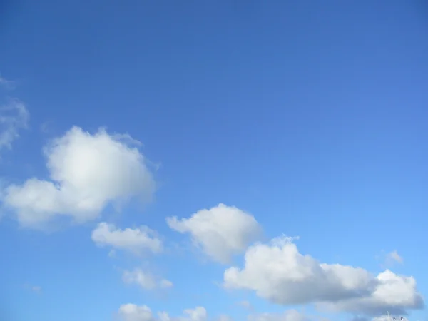 Weiße, flauschige Wolken am blauen Himmel — Stockfoto