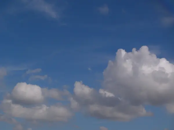 Weiße, flauschige Wolken am blauen Himmel — Stockfoto